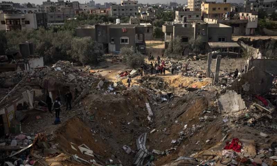 Palestinians inspect a site after it was hit by an Israeli bombardment on Rafah on Tuesday [Fatima Shbair/AP Photo]